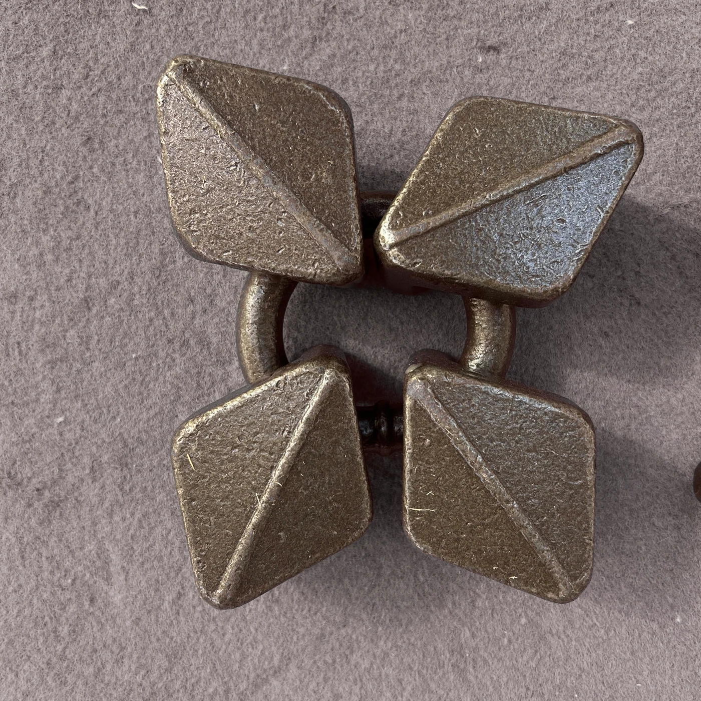 Four broad diamond-shaped metal wear elements connected around a ring
