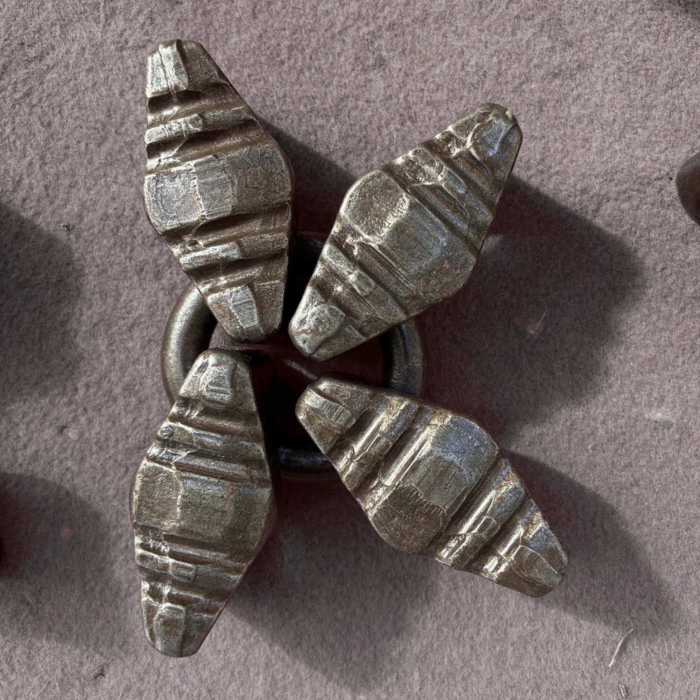 Four elongated ribbed metal wear elements connected around a ring